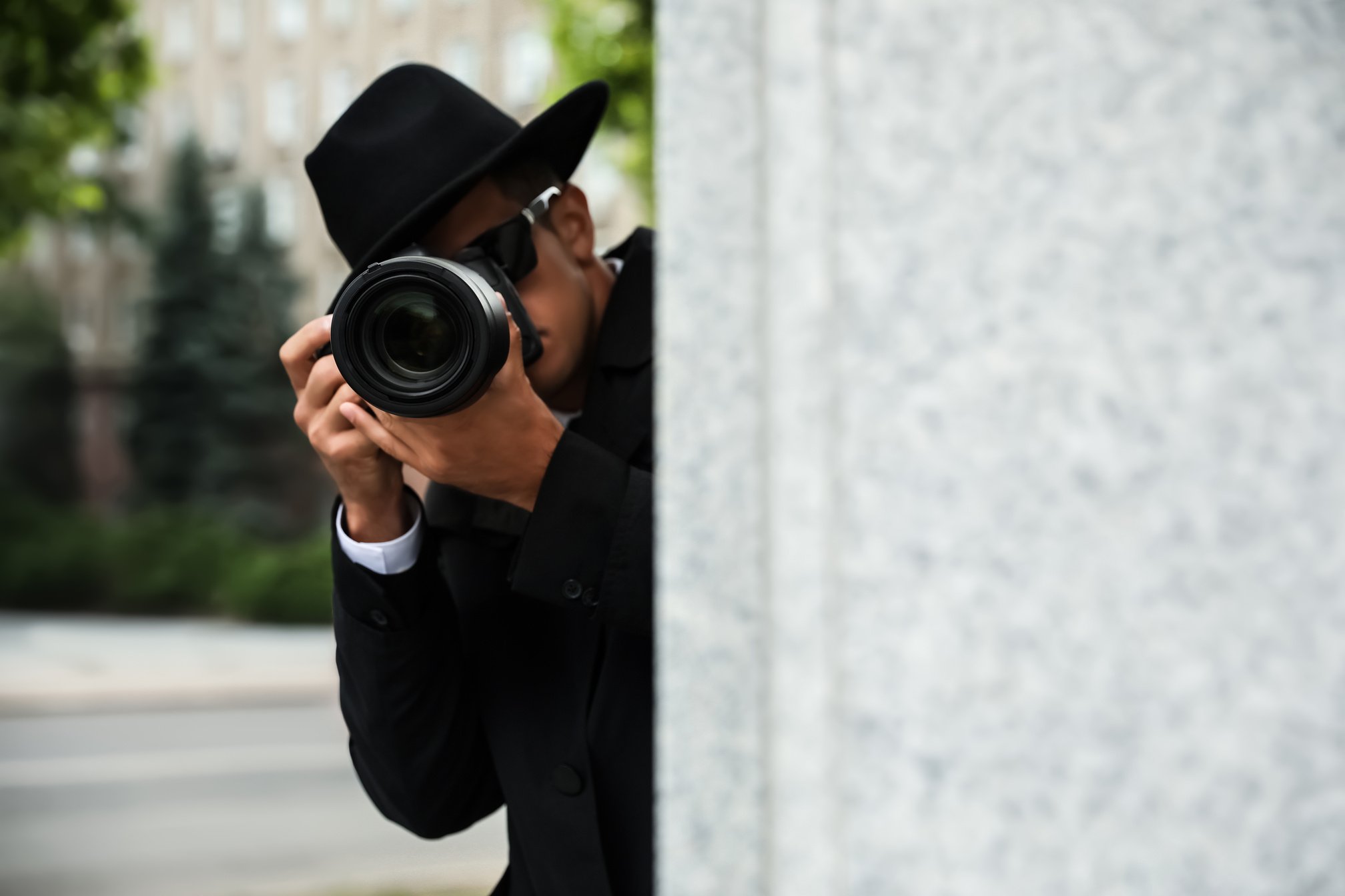 Private Detective with Modern Camera Spying on City Street